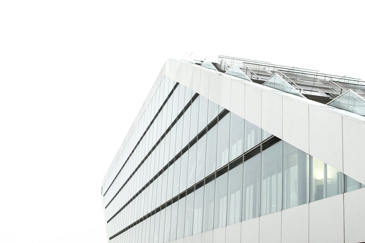 Modern building exterior with white panels and reflective glass windows.