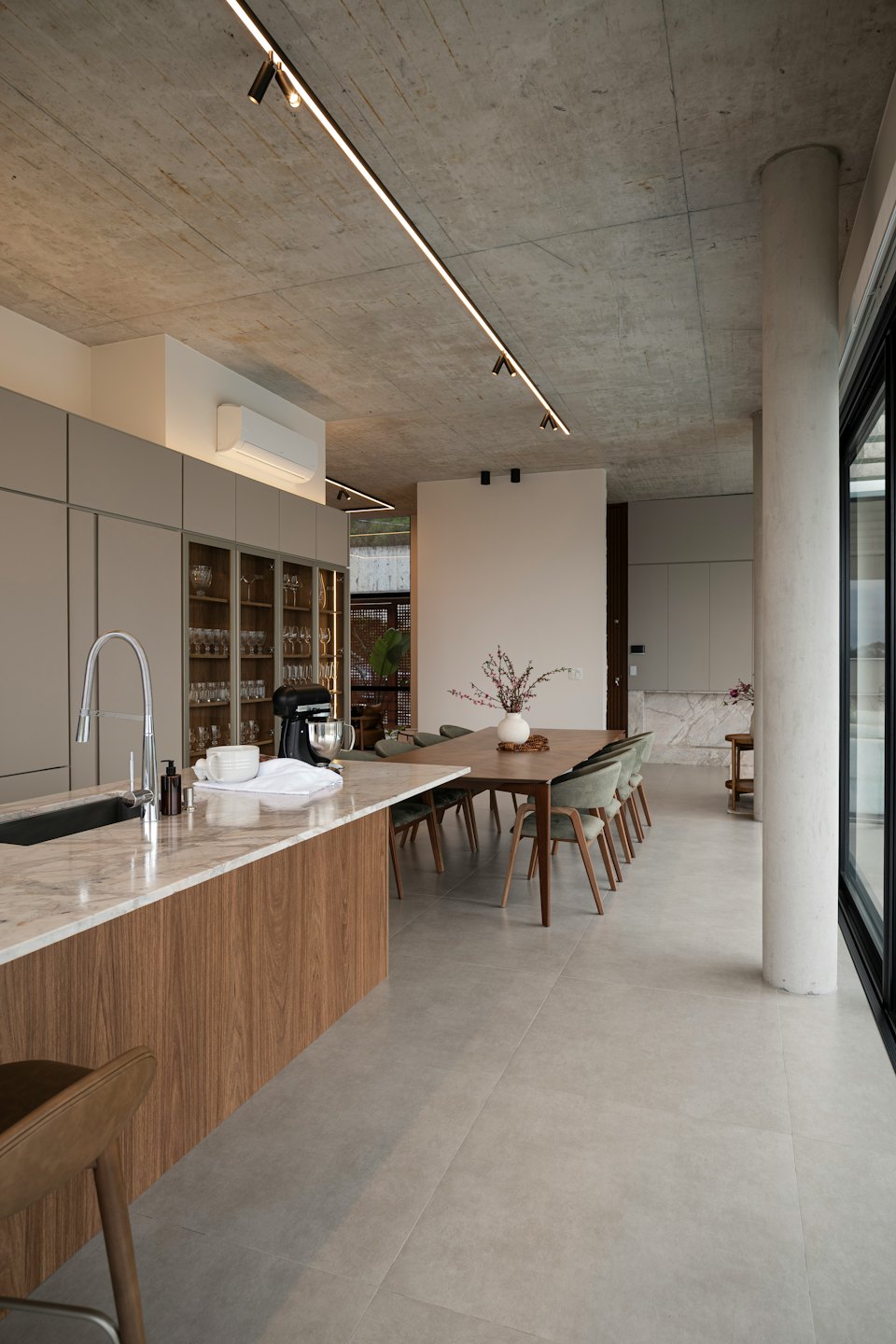 Modern kitchen island with marble countertop next to dining table.